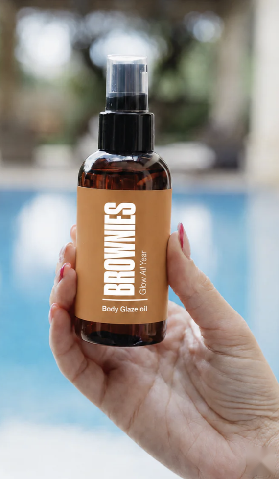 Brownies Dark mousse and Brownie Butter cellulite balm held by Mediterranean pool