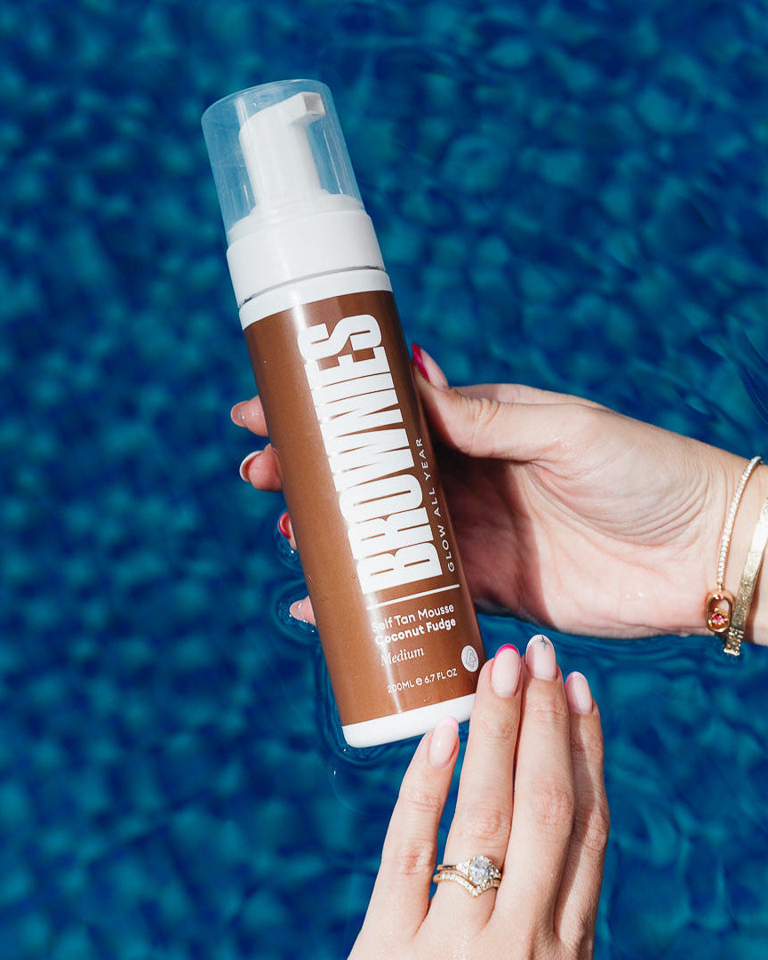 Brownies Coconut Fudge self-tan mousse held over pool water