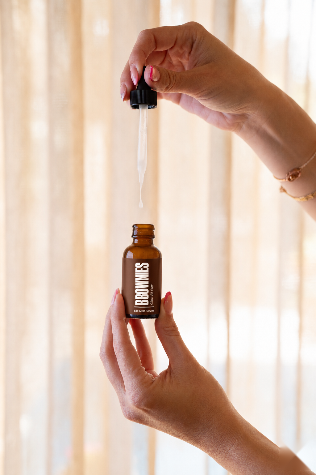 Silk Melt Serum dropper releasing plumping serum drop into amber bottle